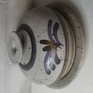 Covered pottery dish speckled background